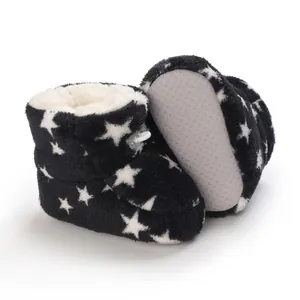 Detalle de botitas de peluche para bebé con estampado de estrellas y suelas antideslizantes