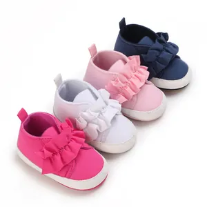 Detailansicht von bunten Baby-Lauflernschuhen mit weicher Sohle und Rüschen.