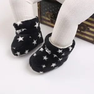 Primer plano de botas de felpa de invierno para bebé con patrón de estrellas y forro suave