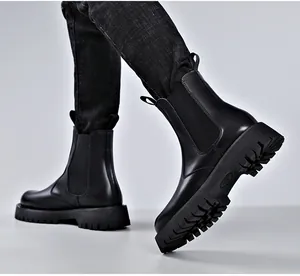 Vista detallada de los botines Chelsea de cuero negro para hombre con suela gruesa