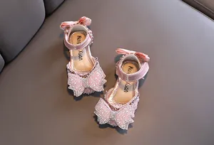 Detailansicht der rosa Prinzessinnen-Sandalen mit Strass- und Perlen-Schleifen.