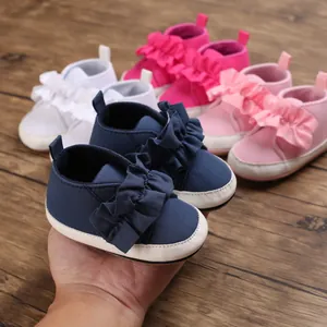 Nahaufnahme von weichen marineblauen Lauflernschuhen mit Rüschen und bunten Farbvarianten.