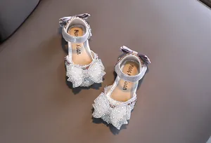 Nahaufnahme der silbernen Prinzessinnen-Sandalen für Mädchen mit Perlen und Schleife