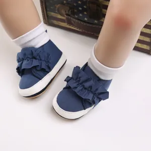 Detailansicht marineblauer Baby-Lauflernschuhe mit Rüschen und weißer weicher Sohle.