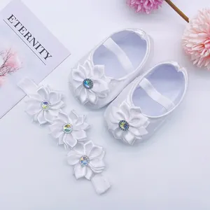 Detailed view of white satin baby princess shoes and matching floral headband set for infants