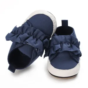 Detailansicht von dunkelblauen Baby-Lauflernschuhen mit schicken Rüschen-Akzenten.