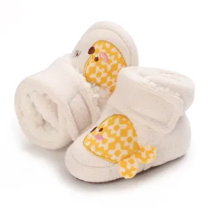 Vue détaillée de bottes de neige pour bébé fourrées avec un joli motif de poisson jaune