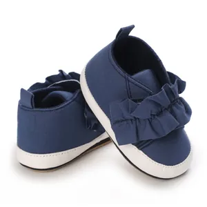 Detailansicht dunkelblauer Babyschuhe mit Rüschenakzenten und weicher weißer Sohle