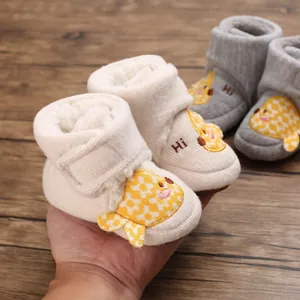 Gros plan montrant la doublure en peluche douce et le design poussin des bottes bébé hiver.