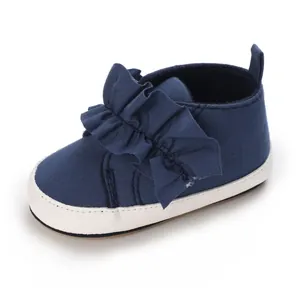 Dunkelblauer Baby-Lauflernschuh mit weicher Sohle und dekorativer Rüschenschleife