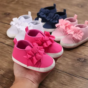 Detailansicht pinkfarbener Babylauflernschuhe mit Rüschendetails und einer weichen weißen Sohle.