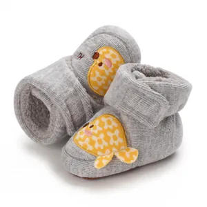 Vue détaillée du chausson bébé gris en tricot avec motif poisson et doublure peluche.