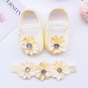 Detailed view of cream satin baby princess shoes with floral rhinestone headband set.