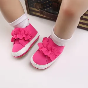 Detailansicht der pinkfarbenen Baby-Lauflernschuhe mit Rüschen und weichen Sohlen