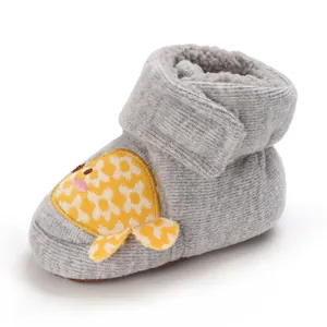 Gros plan de bottes de neige pour bébé en tricot gris avec doublure en polaire et motif poisson