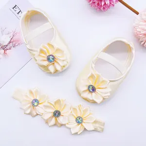 Detail view of infant princess shoes and matching floral headband set with soft soles