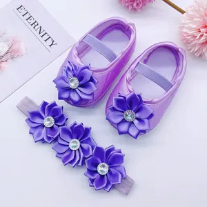 Detail of purple baby princess shoes and matching floral headband with rhinestone