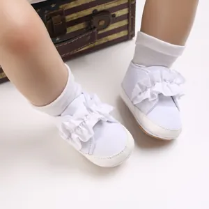 Detailansicht der weißen Babyschuhe mit Rüschenbesatz und flexibler, weicher Sohle