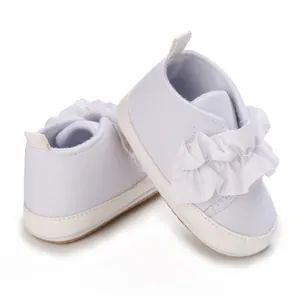 Detailansicht der weißen Baby-Lauflernschuhe mit eleganten weichen Rüschendekorationen