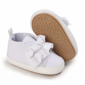 Detailansicht weißer Baby-Lauflernschuhe mit weicher Sohle und großer Schleife.