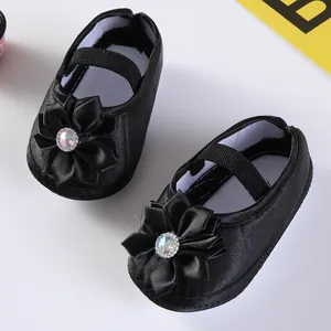 Detailansicht der schwarzen Baby-Prinzessinenschuhe aus Satin mit Strass-Blumendekor