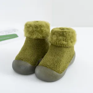 Detalle de zapatos tipo calcetín verde oliva para bebé con cuello de piel y suela de goma suave.