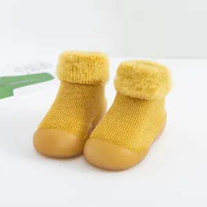Detalle de zapatos calcetín amarillos de invierno para bebé con forro de pelo cálido