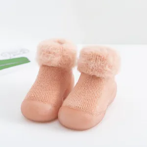 Primer plano de botas de invierno para bebé con ribete de pelo sintético y suelas de goma