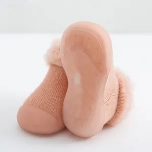 Detalle de zapato tipo calcetín rosa para bebé con suela de goma antideslizante suave