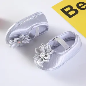 Detailansicht der Blumenverzierung und Satingewebe auf Baby-Prinzessinnenschuhen