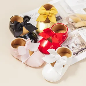Vista detallada de varios colores de zapatos brillantes para bebé con lazo suave