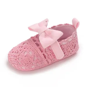 Nahaufnahme rosa gehäkelter Babyschuh mit großer Schleife und weicher Sohle