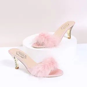 Elegante rosa High Heel Sandalen mit flauschigem Federriemen und goldenem Stöckelabsatz.