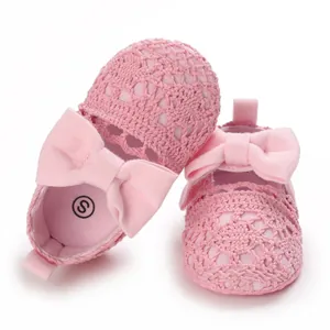 Nahaufnahme von rosa Häkel-Babyschuhen für Mädchen mit weicher Sohle und dekorativer Schleife