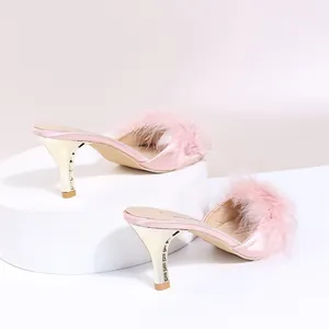 Detailansicht rosa Satin-Mules mit Federbesatz und eleganten goldenen Absätzen