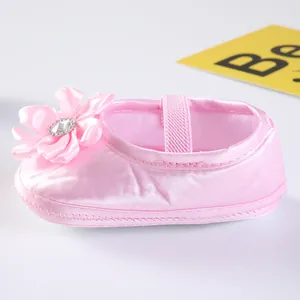 Detailansicht der rosafarbenen weichen Prinzessinnenschuhe für Babys mit Zierblume.