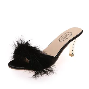 Elegante schwarze Sandalen mit hohen Absätzen, flauschigem Kunstpelz und Goldnieten