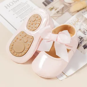 Vista detallada de zapatos de bebé rosa con lazo y suela antideslizante para niñas