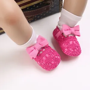 Detailaufnahme der handgefertigten rosa gehäkelten Babyschuhe mit süßer Schleifenverzierung