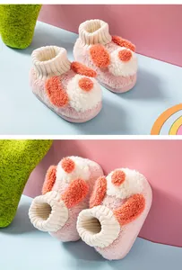 Detail view of plush puppy slippers for toddlers in soft pink and white colors.