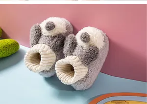 Close-up of grey plush baby slippers with cute rabbit ears and warm lining