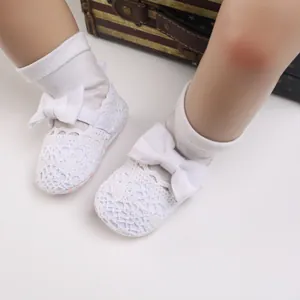 Detailansicht der weißen Spitzen-Häkelschuhe für Babys mit einer weichen Schleife