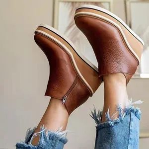 Close-up view of vintage brown wedge ankle boots with platform sole and side zipper.