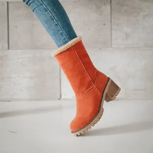 Side view detail of stylish orange suede mid-calf boots with chunky heel and fur trim