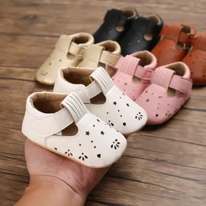 Nahaufnahme von weißen Babyschuhen mit weicher Sohle und Sternenmuster in der Hand