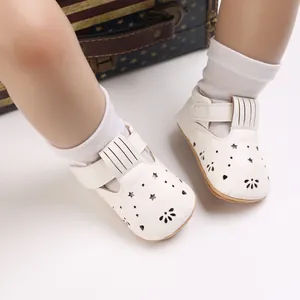 Nahaufnahme weißer Lauflernschuhe für Babys mit Stern-Ausschnitten und Gummisohle.