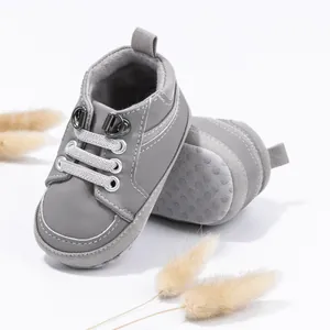 Nahaufnahme von grauen Babylauflernschuhen mit rutschfester Weichsohle und Schnürsenkeln