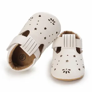 Nahaufnahme weißer Lauflernschuhe für Babys mit Stern- und Herzausschnitten, weiche Sohle