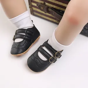 Close-up detail of black baby princess shoes with double straps and soft soles.