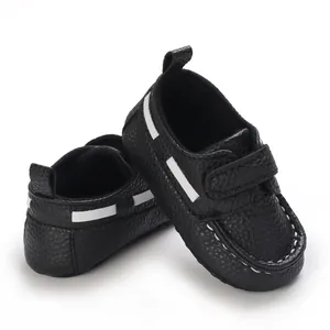 Detailansicht der schwarzen Babyschuhe mit weicher Sohle und weißen Akzenten im Lederlook